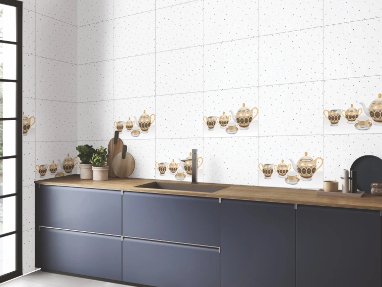 Elegant kitchen backsplash design with white tiles, golden tea set accents, and delicate grey speckles.